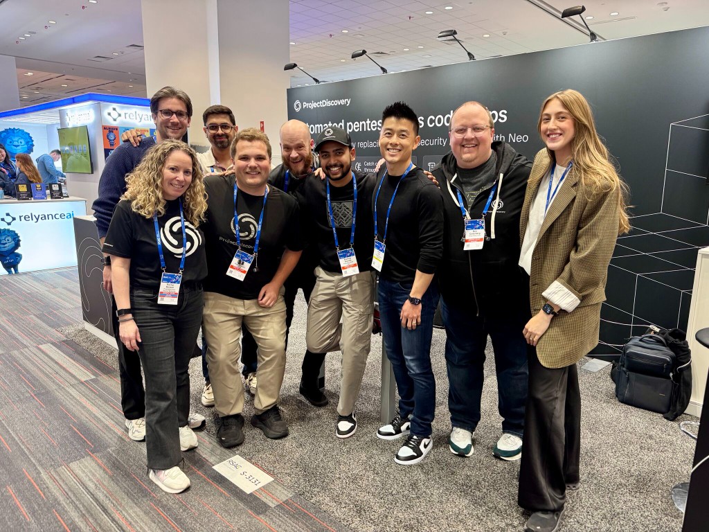 ProjectDiscovery team demoing Neo at RSAC in front of the booth.